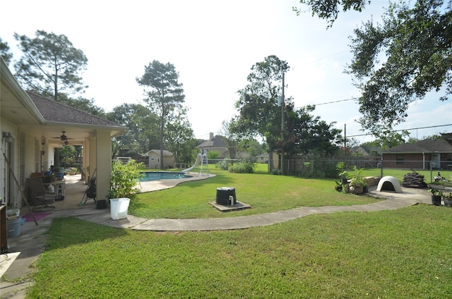 view of yard featuring ceiling fan, a fenced in pool, and a patio area