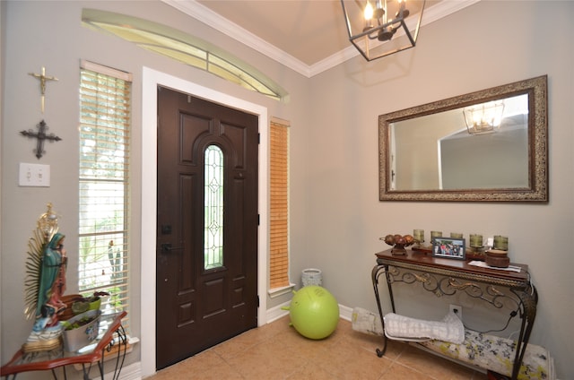 tiled foyer with a notable chandelier, ornamental molding, and a healthy amount of sunlight