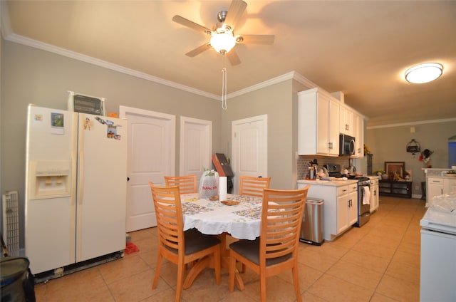 tiled dining space featuring ceiling fan and crown molding