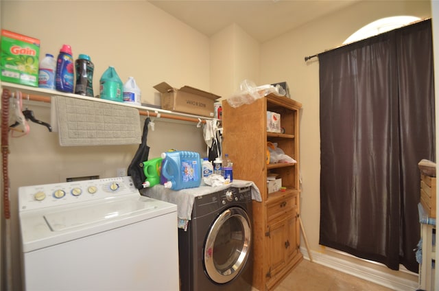 clothes washing area with washing machine and dryer and light tile patterned floors