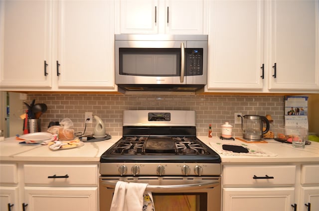 kitchen with appliances with stainless steel finishes, decorative backsplash, white cabinets, and light stone counters