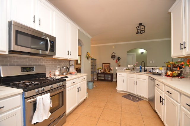 kitchen with backsplash, stainless steel appliances, white cabinetry, sink, and crown molding