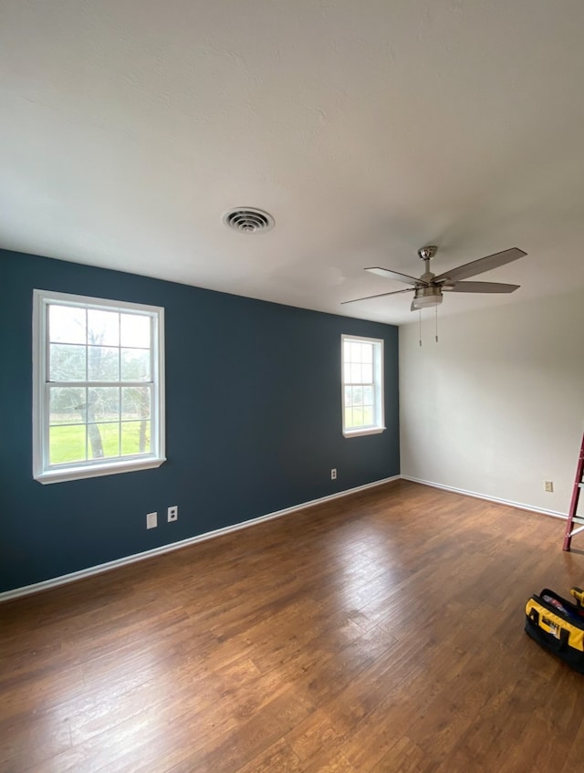 unfurnished room featuring hardwood / wood-style floors, a wealth of natural light, and ceiling fan