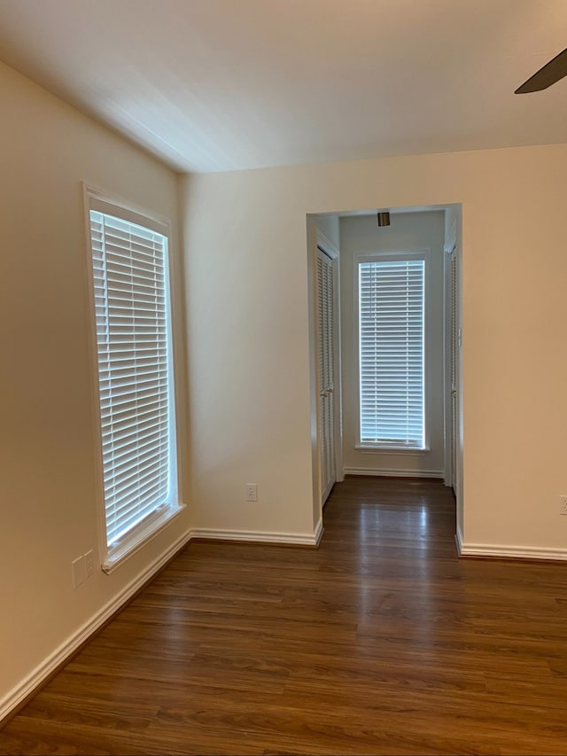 spare room with ceiling fan and dark wood-type flooring