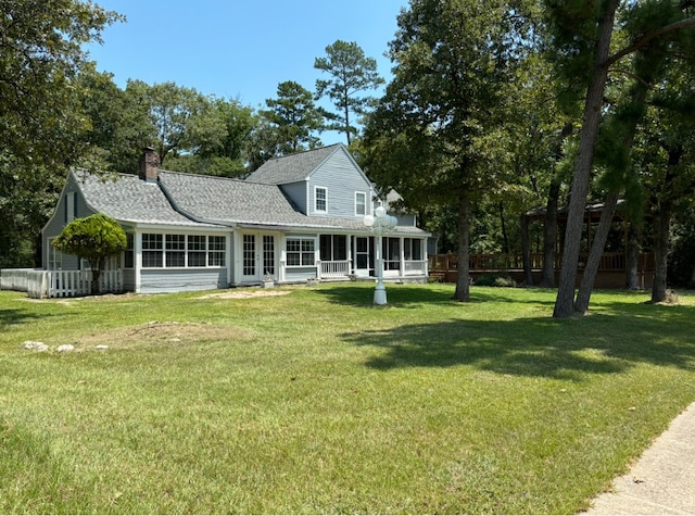 rear view of house featuring a yard