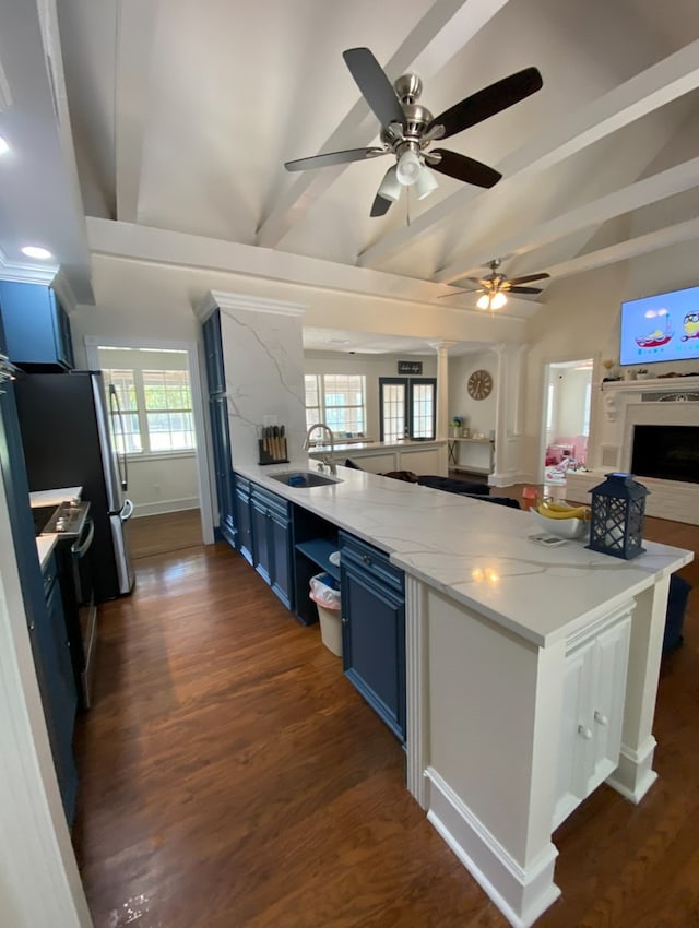 kitchen with sink, dark hardwood / wood-style flooring, ceiling fan, kitchen peninsula, and blue cabinetry