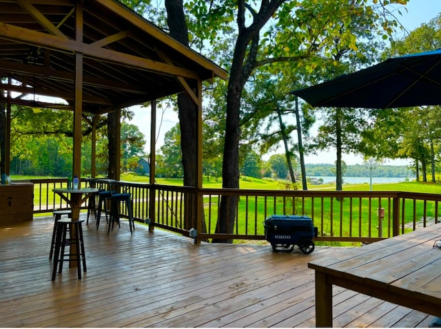 deck with a water view and a yard