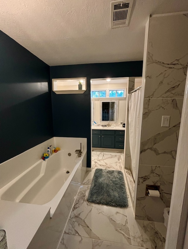 bathroom with tile patterned floors, a textured ceiling, vanity, and shower with separate bathtub