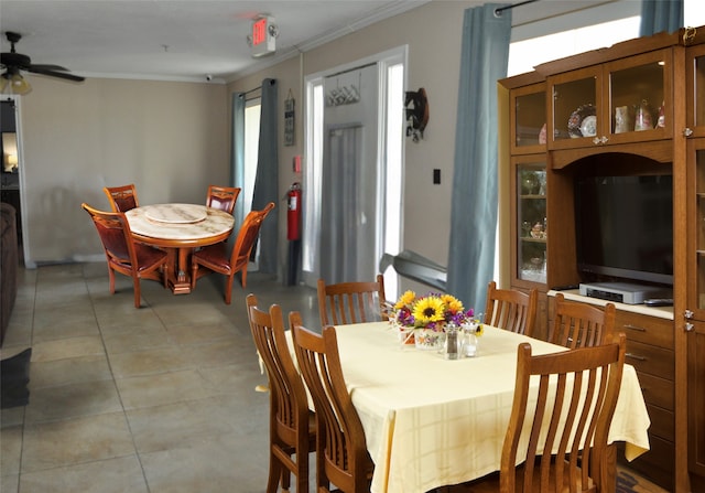 dining area featuring ceiling fan, light tile patterned floors, and ornamental molding