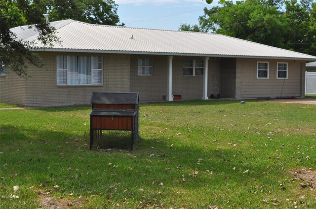 3315 Fm 523rd Rd, Oyster Creek, TX 77541 - back of house featuring a yard, brick siding, and metal roof