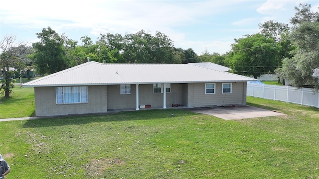 3315 Fm 523rd Rd, Oyster Creek, TX 77541 - back of property with a yard, brick siding, fence, metal roof, and a patio
