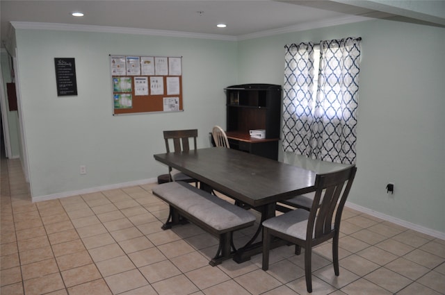 dining space featuring crown molding and light tile patterned flooring