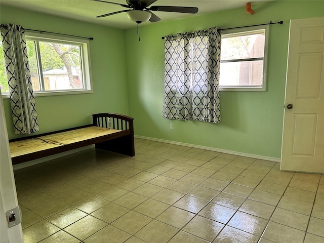 3315 Fm 523rd Rd, Oyster Creek, TX 77541 - unfurnished bedroom featuring light tile patterned floors, ceiling fan, and baseboards