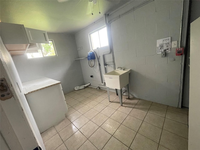 3315 Fm 523rd Rd, Oyster Creek, TX 77541 - laundry room with concrete block wall, light tile patterned floors, laundry area, and plenty of natural light