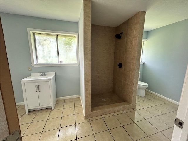 3315 Fm 523rd Rd, Oyster Creek, TX 77541 - bathroom featuring a tile shower, tile patterned floors, toilet, vanity, and baseboards