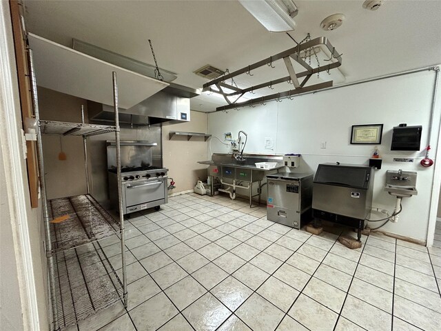 3315 Fm 523rd Rd, Oyster Creek, TX 77541 - kitchen featuring light tile patterned floors, visible vents, high end stove, and baseboards