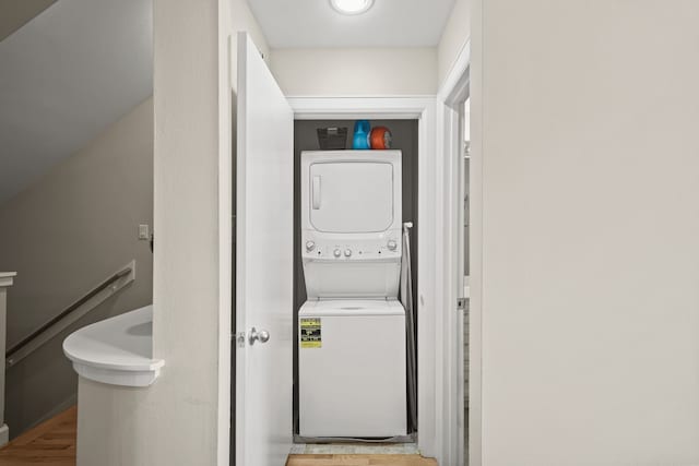 washroom featuring stacked washing maching and dryer and light hardwood / wood-style floors