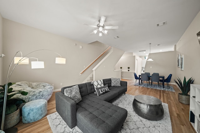 living room with ceiling fan and light hardwood / wood-style flooring