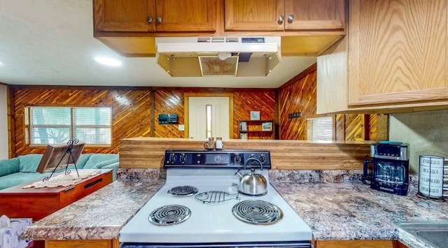 kitchen with white stove and wood walls