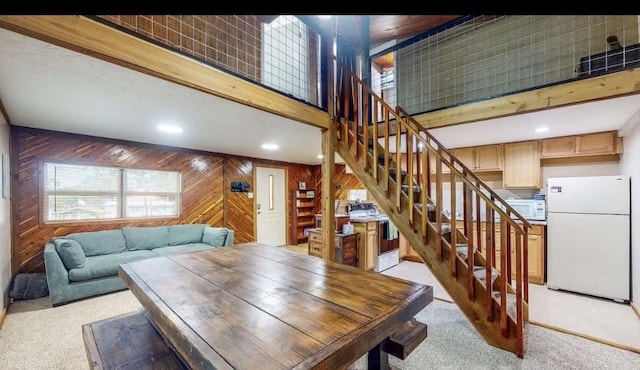 dining room featuring light carpet and wooden walls