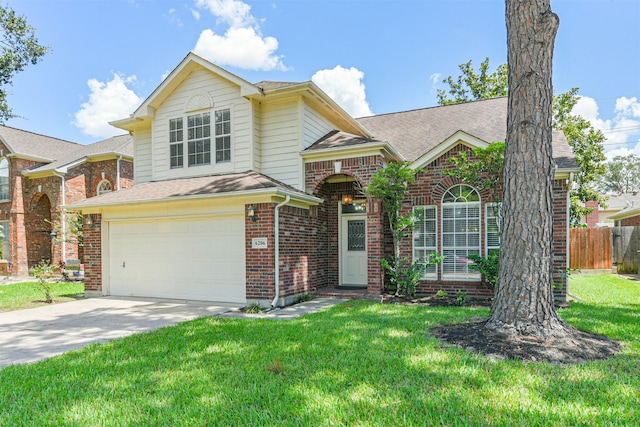 traditional home with driveway, brick siding, an attached garage, fence, and a front yard