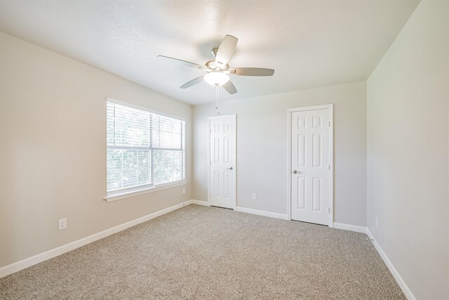 spare room with ceiling fan and carpet