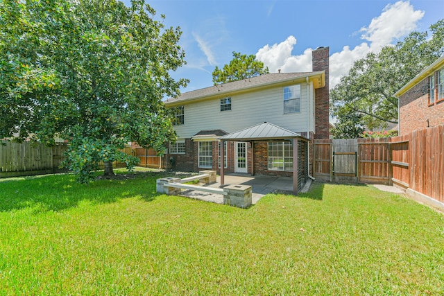 rear view of house featuring a patio and a yard