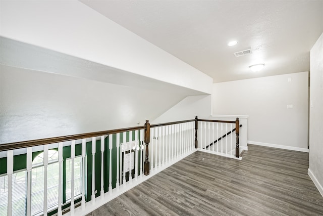 hall featuring lofted ceiling and hardwood / wood-style floors