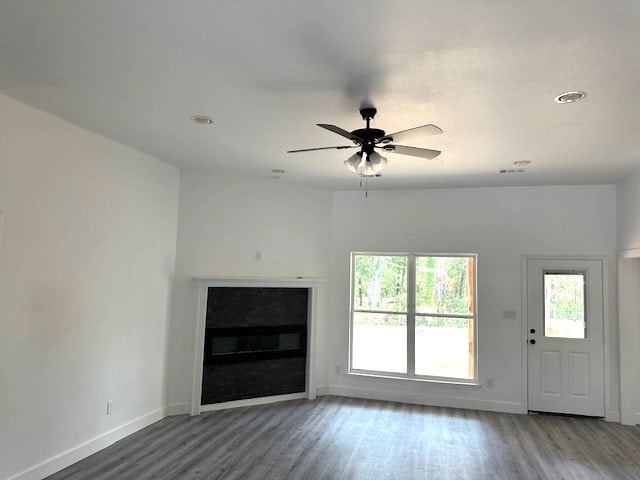 24629 Waterford St, Hempstead, TX 77445 - unfurnished living room with a glass covered fireplace, baseboards, a ceiling fan, and wood finished floors