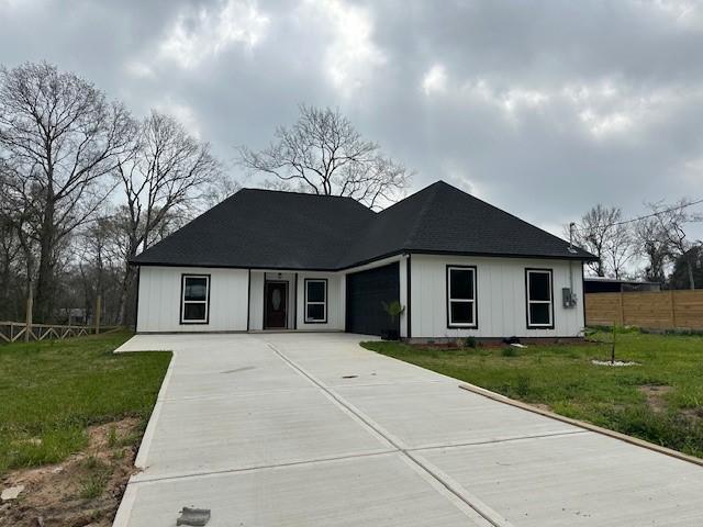 24629 Waterford St, Hempstead, TX 77445 - view of front of house featuring an attached garage, concrete driveway, fence, and a front lawn