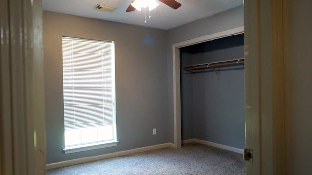 unfurnished bedroom featuring ceiling fan, a closet, and carpet flooring