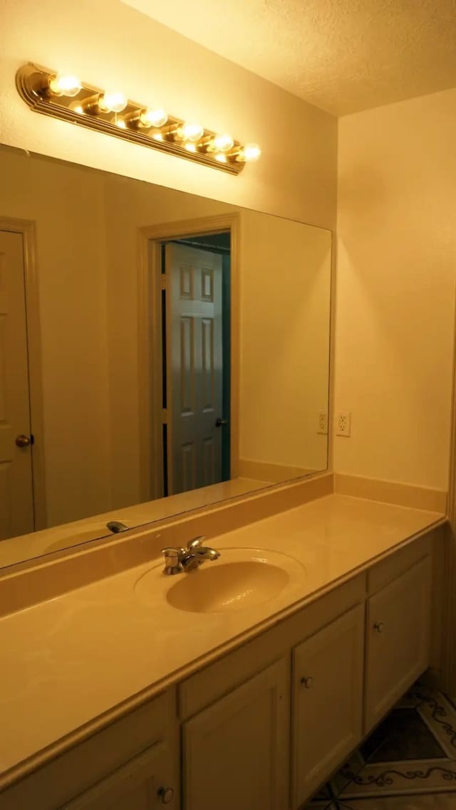 bathroom with a textured ceiling, vanity, and tile patterned floors