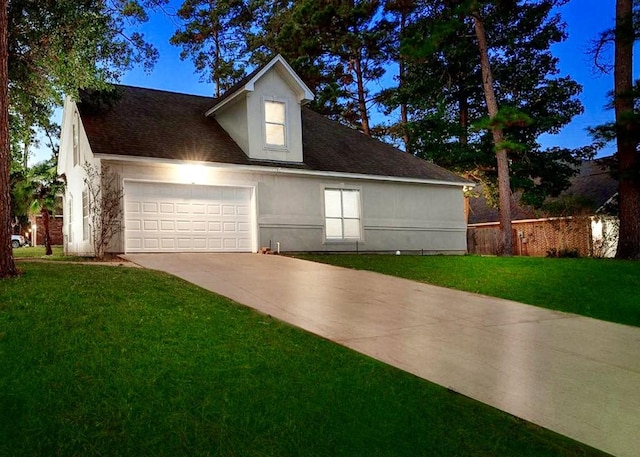 view of front of home with driveway, a front lawn, an attached garage, and stucco siding