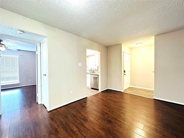 empty room with hardwood / wood-style flooring, ceiling fan, baseboards, and a textured ceiling