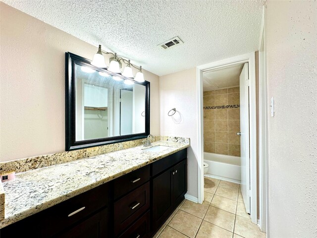 full bath featuring visible vents, toilet, tile patterned floors, a textured ceiling, and vanity