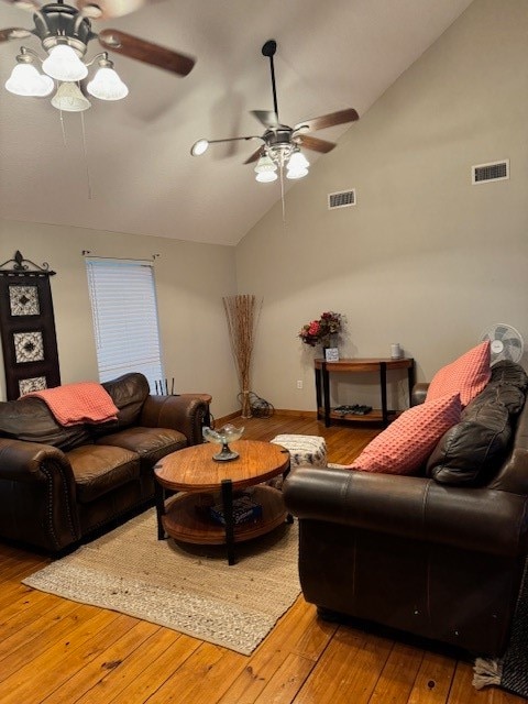 living room with ceiling fan, high vaulted ceiling, and light hardwood / wood-style flooring