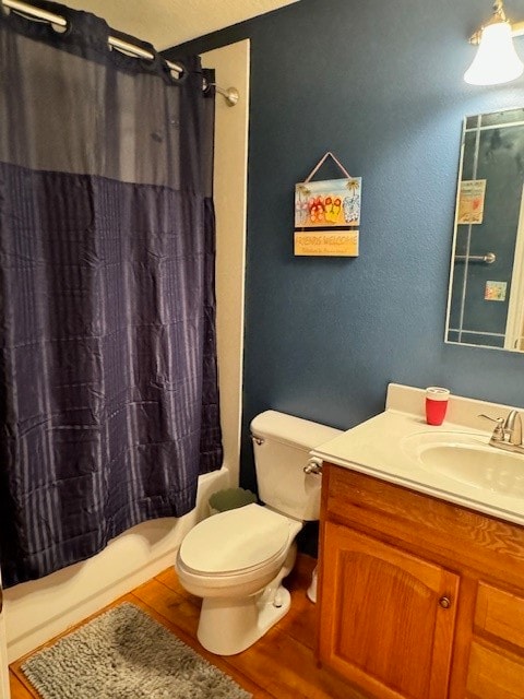 full bathroom with toilet, hardwood / wood-style flooring, vanity, and shower / bath combo with shower curtain