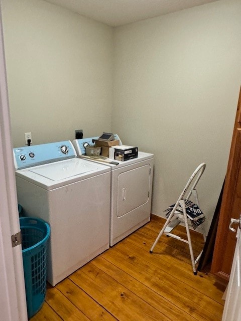 clothes washing area with light wood-type flooring and washer and dryer