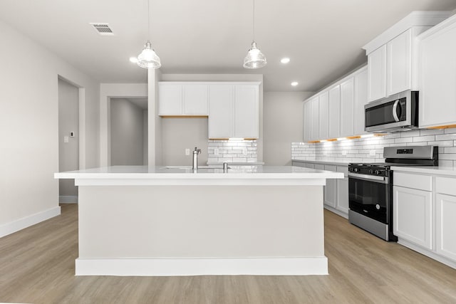 kitchen with tasteful backsplash, stainless steel appliances, and a kitchen island with sink