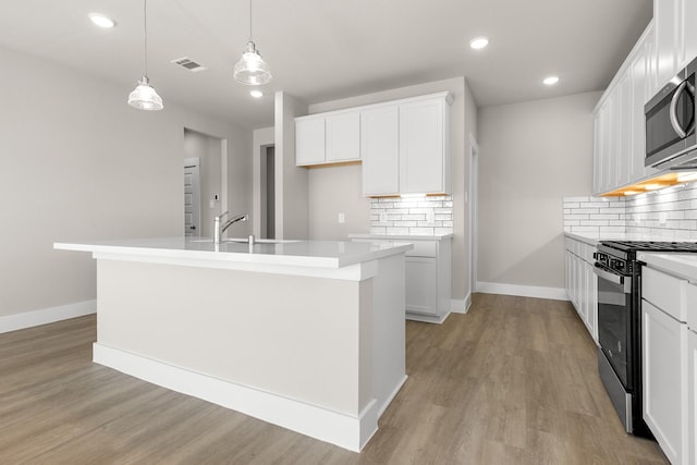 kitchen with pendant lighting, white cabinetry, backsplash, and appliances with stainless steel finishes