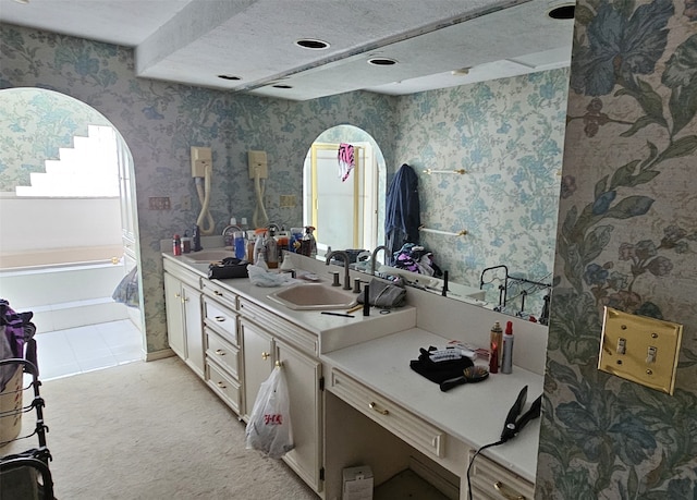 kitchen with light tile patterned floors, sink, and a textured ceiling