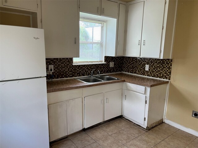 kitchen featuring sink, light tile patterned flooring, decorative backsplash, and white refrigerator