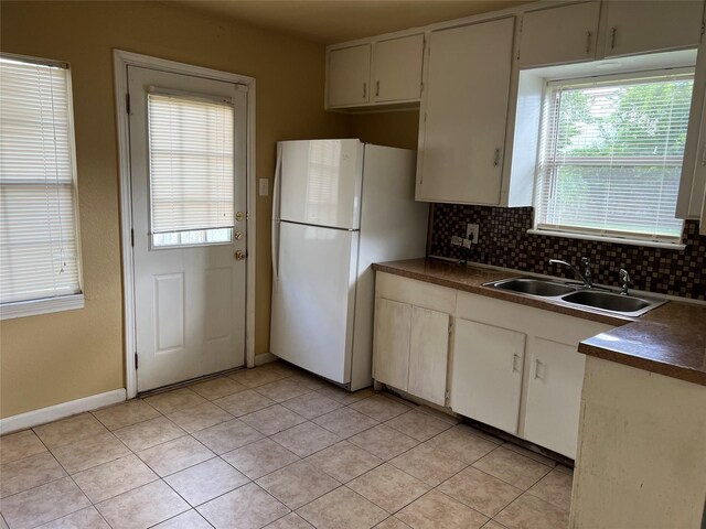 kitchen featuring sink, white fridge, backsplash, and light tile patterned floors