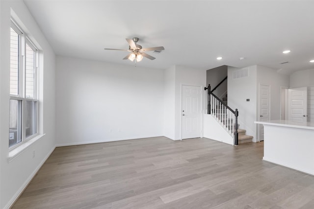 spare room with ceiling fan and light wood-type flooring