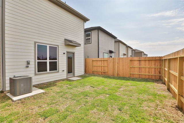 rear view of property featuring a yard and central AC