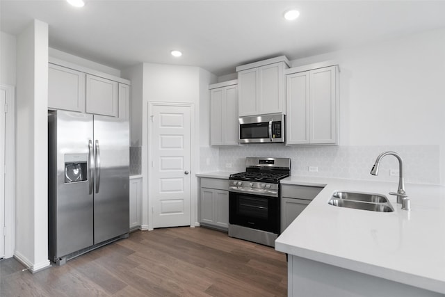 kitchen featuring hardwood / wood-style floors, appliances with stainless steel finishes, sink, and tasteful backsplash