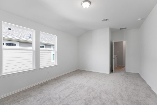 carpeted empty room with lofted ceiling