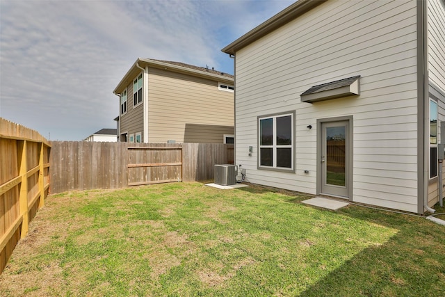 rear view of house with a lawn and central air condition unit