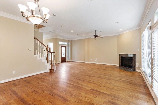 unfurnished living room with light wood-type flooring, crown molding, and a high end fireplace