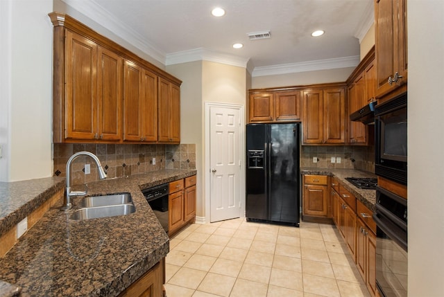 kitchen featuring visible vents, brown cabinetry, crown molding, black appliances, and a sink